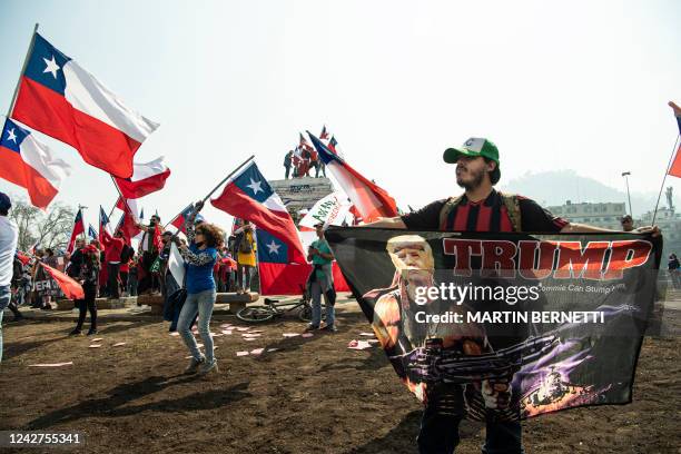 Man holds a flag with an image of former US President Donald Trump during a demonstration against the draft of the new constitution in Santiago, on...