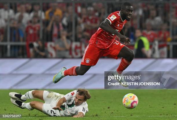 Bayern Munich's French defender Dayot Upamecano jumps over Moenchengladbach's German defender Tony Jantschke during the German first division...