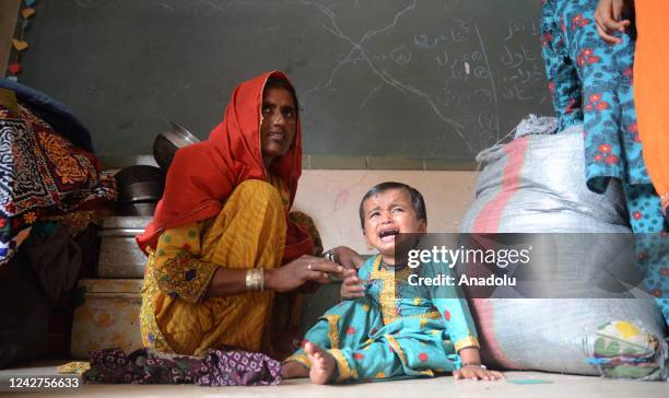 Displaced people wait to get food and other assistance after fleeing their flood-hit homes, from different districts of Karachi, Pakistan, on August...