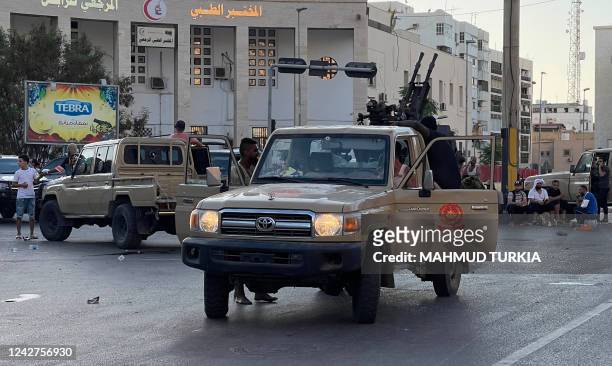 Fighters loyal to the Government of National Unity are pictured in a street in the Libyan capital Tripoli on August 27 following clashes between...
