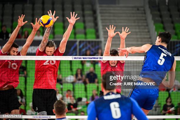 Canadas Ryan Joseph Sclater, Canadas Arthur Szwarc and Canadas Eric Loeppky try to block Italys Alessandro Michieletto during the World Volleyball...
