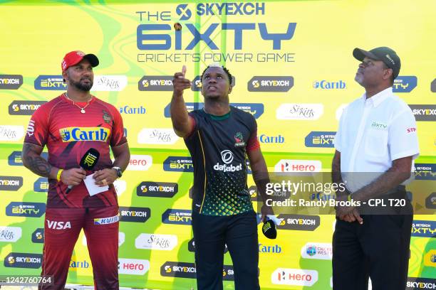 Evin Lewis of St Kitts & Nevis Patriots toss the coin as Ravi Rampaul of Trinbago Knight Riders and match referee Denavon Hayles look on during the...
