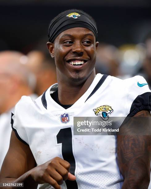 Travis Etienne Jr. #1 of the Jacksonville Jaguars smiles on the sidelines during the second half of the preseason game against the Atlanta Falcons at...