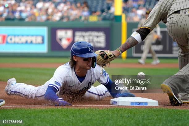 Bobby Witt Jr. #7 of the Kansas City Royals slides into third for a steal past Manny Machado of the San Diego Padres in the first inning at Kauffman...