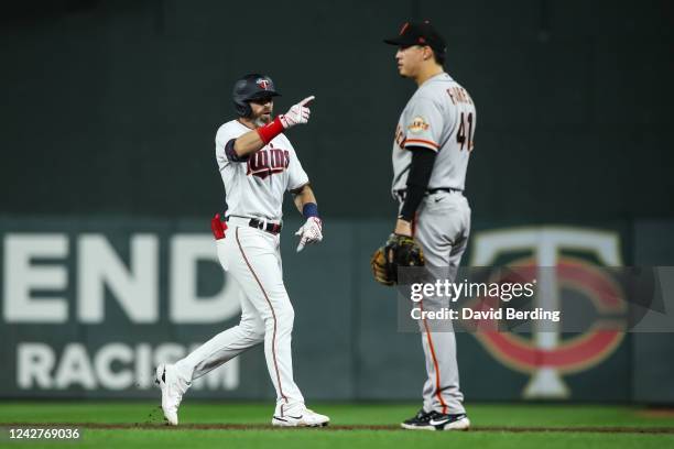 Jake Cave of the Minnesota Twins celebrates his RBI single while Wilmer Flores of the San Francisco Giants looks on in the ninth inning of the game...