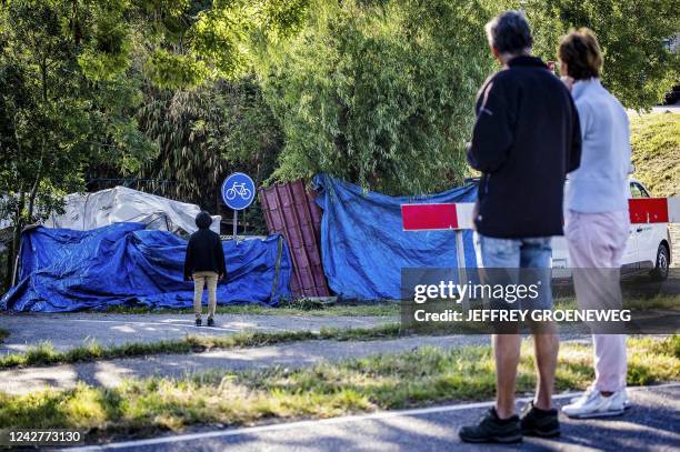 Local residents look at the scene in Nieuw-Beijerland on August 28, 2022 where a truck crashed into a group of people dining out near Rotterdam on...