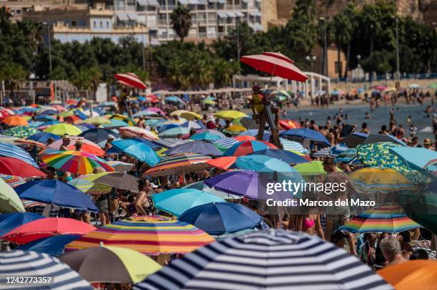 El Postiguet Beach is seen crowded during a hot summer day while many tourists and locals sunbathe and cool off. The tourist industry in the province...