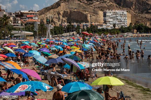 El Postiguet Beach is seen crowded during a hot summer day while many tourists and locals sunbathe and cool off. The tourist industry in the province...