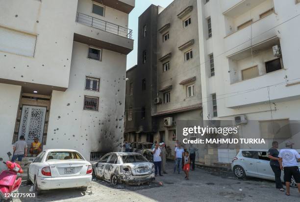 People inspect the damage following clashes between backers of rival governments in Libya's capital Tripoli, on August 28, 2022. - Flights resumed...