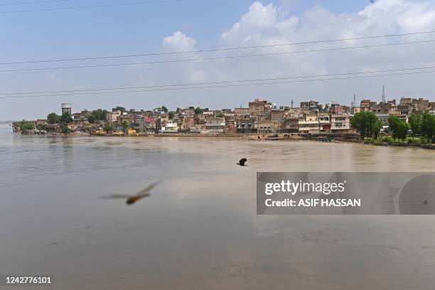 General view of swollen river Indus is pictured along with residential area in flood hit Sukkur of Sindh province on August 28, 2022. - The fate of...