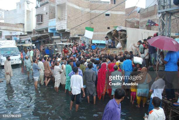 Pakistani army soldiers distribute food among flood victims place following a flash flood in Hyderabad southern Sindh province, Pakistan on August...