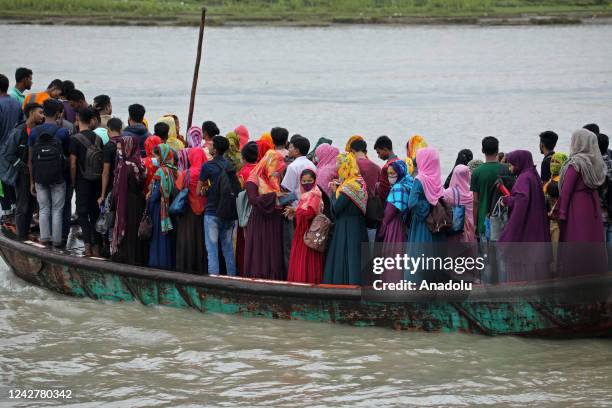 Crowd of climate migrant workers hurries cross the Poshur river to attend to their office in time by boat at Mongla city in Bagerhat, Bangladesh on...