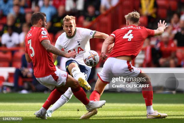 Tottenham Hotspur's English striker Harry Kane shoots between Nottingham Forest's English defender Steve Cook and Nottingham Forest's English...