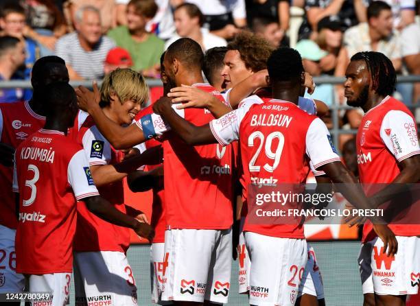 Reims' Japanese forward Junya Ito celebrates with teammates after scoring the 1-0 goal during the French L1 football match between Stade de Reims and...