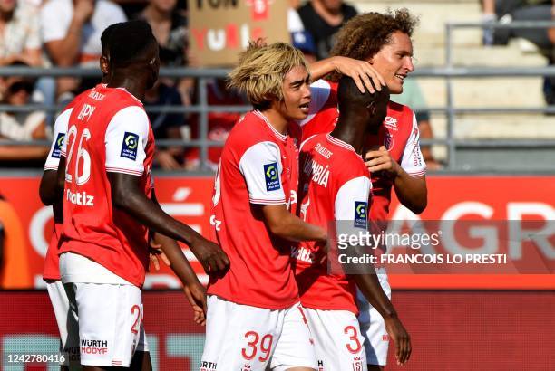 Reims' Japanese forward Junya Ito celebrates with teammates after scoring the 1-0 goal during the French L1 football match between Stade de Reims and...