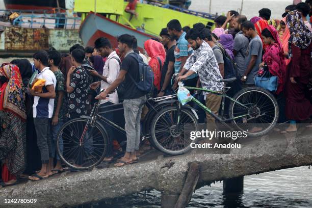 Crowd of climate migrant workers hurries cross the Poshur river to attend to their office in time by boat at Mongla city in Bagerhat, Bangladesh on...