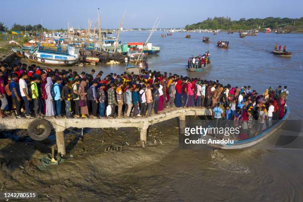 Aerial view of crowd of climate migrant workers hurries cross the Poshur river to attend to their office in time by boat at Mongla city in Bagerhat,...