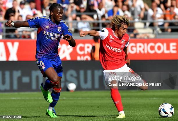 Reims' Japanese forward Junya Ito fights for the ball with Lyon's French defender Castello Lukeba during the French L1 football match between Stade...