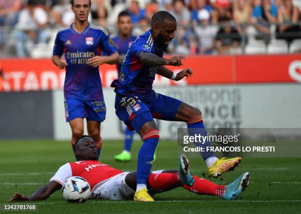 Lyon's French forward Alexandre Lacazette fights for the ball with Reims' Senegalese midfielder Dion Lopy during the French L1 football match between...