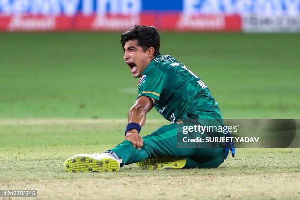 Pakistan's Naseem Shah screams in pain holding his leg after delivering a ball during the Asia Cup Twenty20 international cricket Group A match...