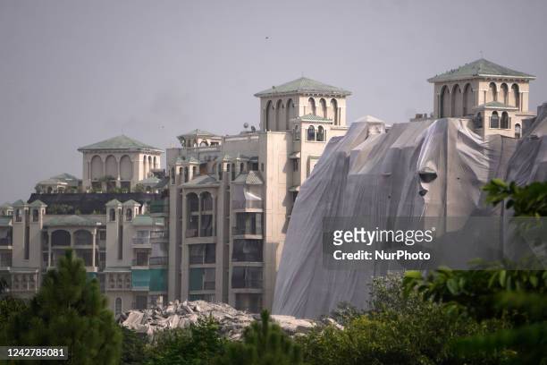Debris is seen near residential buildings as the Supertech Twin Towers collapse following a controlled demolition by explosion after the Supreme...