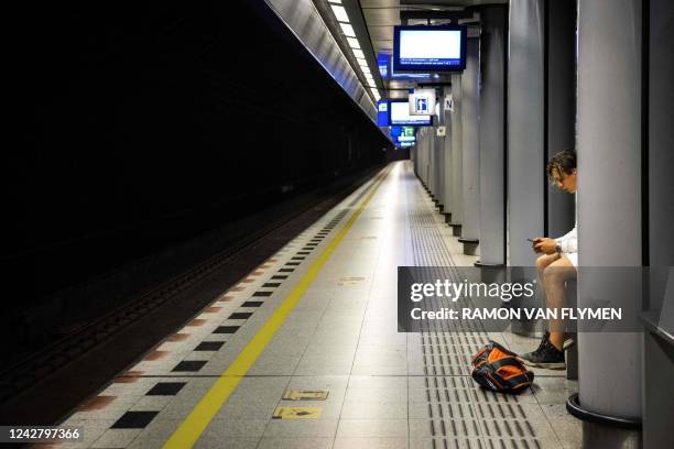 Traveller sits in an empty platform at the Schiphol Airport train station on August 29 during a Dutch Railways strike. - Due to a 24-hour regional...