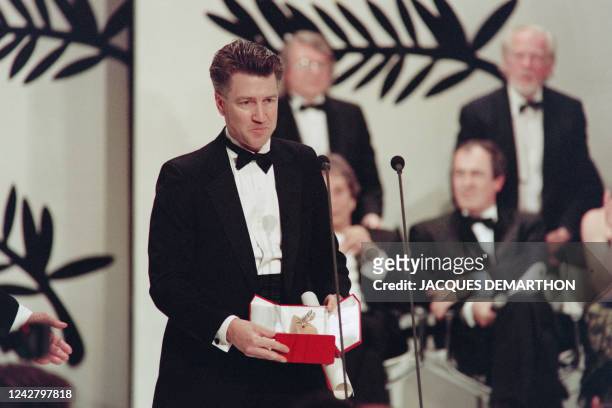 American director David Lynch poses with The Palme d'Or for his movie "Wild at Heart" during the closing ceremony at the 43th edition of the Cannes...