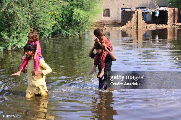 Pakistani flood victims wade through flood water after flash flood in Matiari, Sindh province, Pakistan on August 29, 2022.