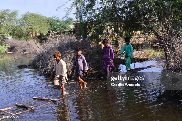 Pakistani flood victims wade through flood water after flash flood in Matiari, Sindh province, Pakistan on August 29, 2022.