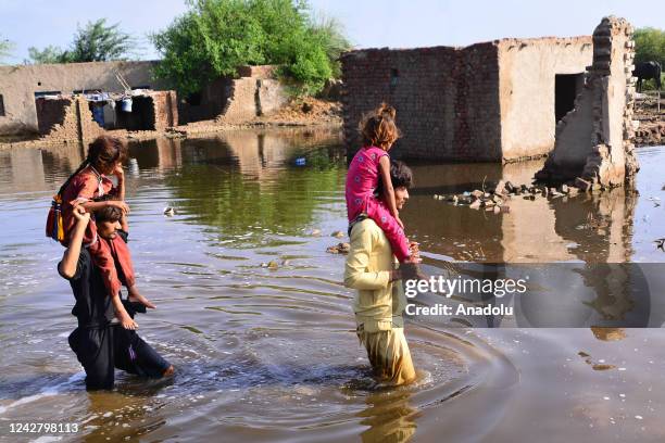 Pakistani flood victims wade through flood water after flash flood in Matiari, Sindh province, Pakistan on August 29, 2022.