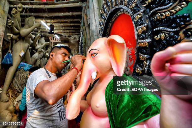 An artist puts the final touches on an idol of Lord Ganesha for the upcoming Ganesh Chaturthi festival at the Artist hub Kumortuli. Ganesh Chaturthi...