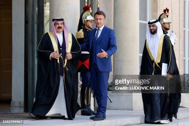 French President Emmanuel Macron welcomes Bahrain's King Hamad bin Isa al-Khalifa and his son, Prince Nasser bin Hamad al-Khalifa, prior to their...