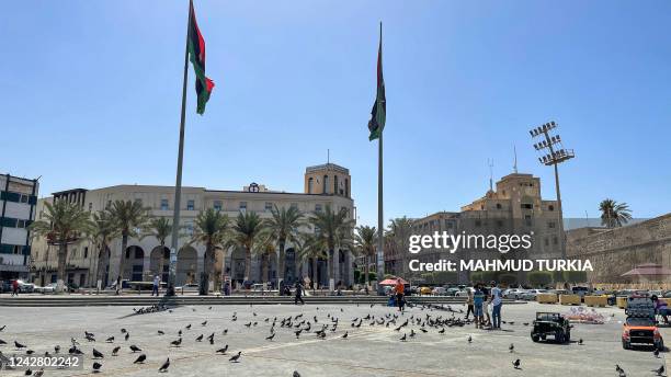 Youths feed pigeons at the Martyrs' Square in the centre Libya's capital Tripoli on August 29, 2022.