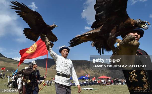 Kyrgyz "berkutchi" carry their birds, golden eagles, during the opening ceremony of the hunting festival "Salburun", in the Chunkurchak gorge, some...