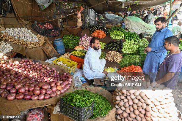 People buy vegetables at a local market in Lahore on August 29 amid a big hike in prices of food items in the wake of massive floods in Pakistan. -...