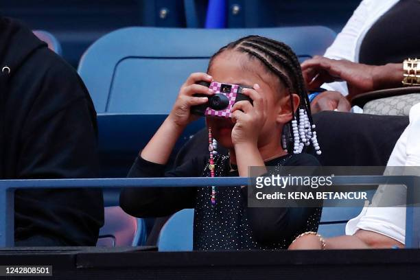 Player Serena Williams' daughter Alexis Olympia takes a picture before her mother plays against Montenegro's Danka Kovinic during their 2022 US Open...