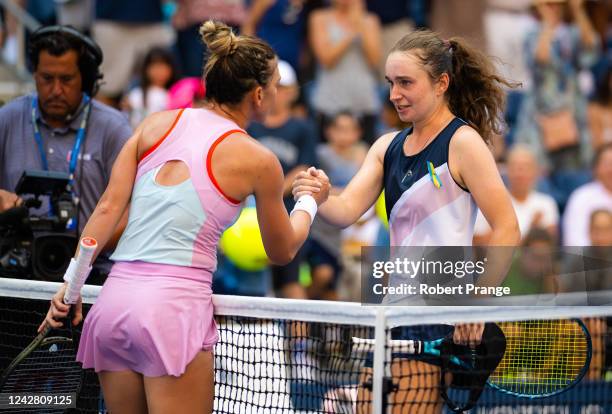 Simona Halep of Romania and Daria Snigur of Ukraine shake hands after their first round match on Day 1 of the US Open Tennis Championships at USTA...