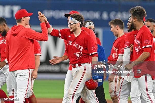 Toronto Blue Jays Catcher Danny Jansen celebrates the winning single with team mates after the regular season MLB game between the Chicago Cubs and...