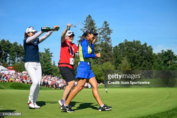 Paula Reto is drenched with champagne by other players after sinking her par putt on 18 to win the 2022 CP Women's Open at the Ottawa Hunt and Golf...