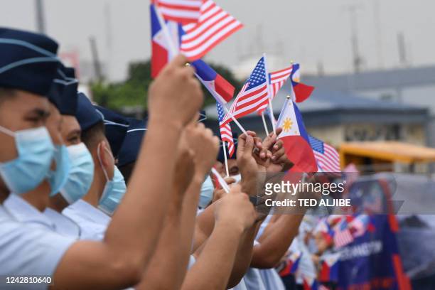 Philippine coast guard personnel wave US and Philippine flags as the US coast Guard cutter Midgett docks at the international port in Manila on...