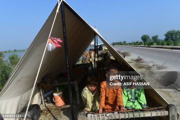 Internally displaced children sit inside a tent along the roadside in a temporary makeshift camp after fleeing from flood-hit homes at Shikarpur in...