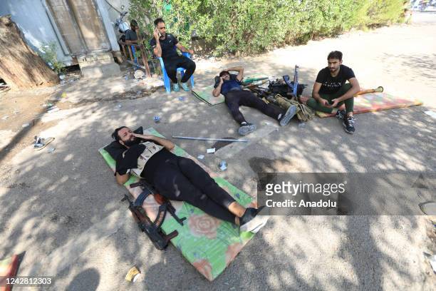Supporters of Iraqi cleric Muqtada al-Sadr rest as they clash with security forces with heavy weapons at Green Zone after Sadr supporters stormed the...