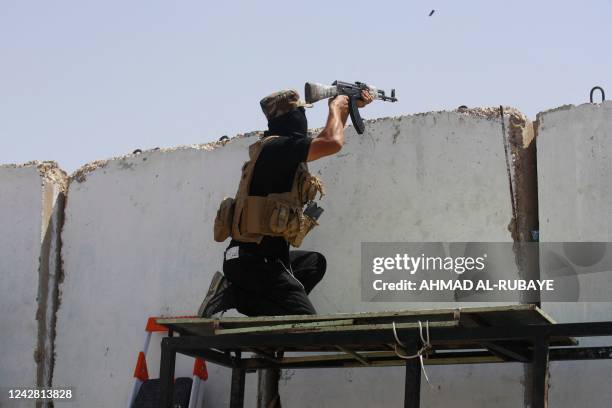 An armed member of Saraya al-Salam , the military wing affiliated with Shiite cleric Moqtada al-Sadr, takes aim during clashes with Iraqi security...