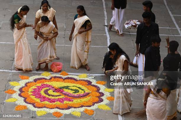 Children prepare a floral 'rangoli', a decorative design made on the occasion of festivals, as part of the 'Onam' festival celebrations at a school...