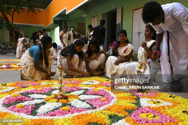 Children prepare a floral 'rangoli', a decorative design made on the occasion of festivals, as part of the 'Onam' festival celebrations at a school...