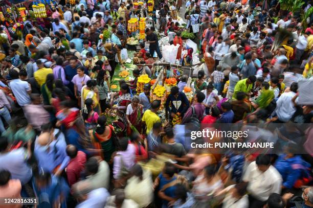 People throng a wholesale flower market ahead of the Ganesh Chaturthi festival in Mumbai on August 30, 2022.