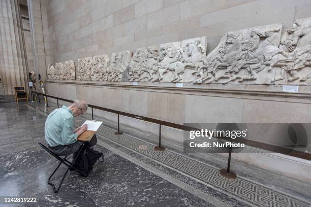 Man as seen painting in front of the marbles. People admire the Parthenon Marbles inside the Parthenon Galleries in the British Museum. The marbles...