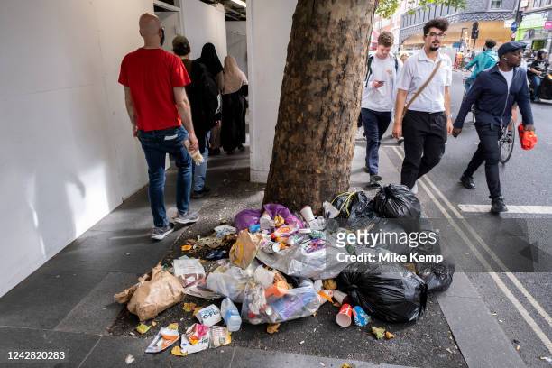 Rubbish bags and accumulated litter, drinks cups, bottles and fast food packaging on Charing Cross Road in central London on 23rd August 2022 in...