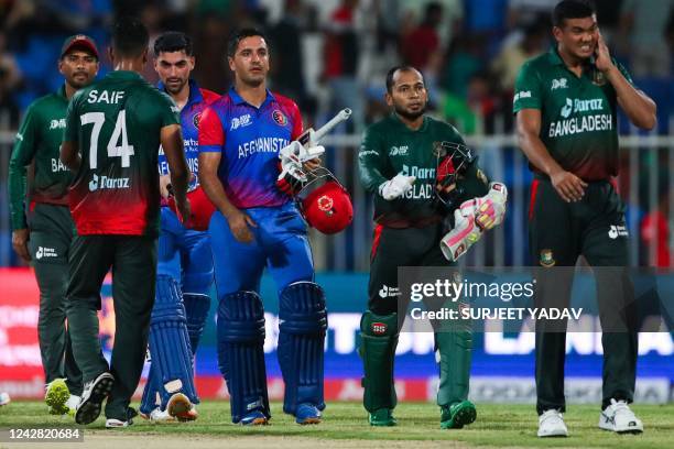 Afghanistan's Najibullah Zadran and teammate Ibrahim Zadran leave with Bangladesh's players after winning the Asia Cup Twenty20 international cricket...