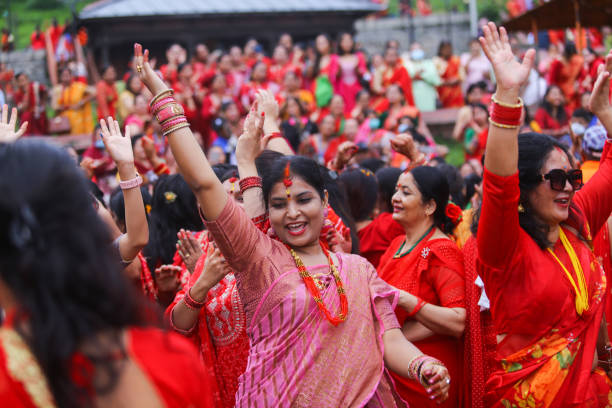 Nepalese Hindu women sing and dance after paying homage to Lord Shiva, the Hindu god of destruction at the premises of Pashupatinath Temple during...